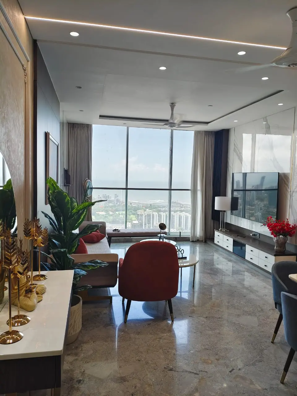 Adani Monte South: A living room with full-height windows and a sea view