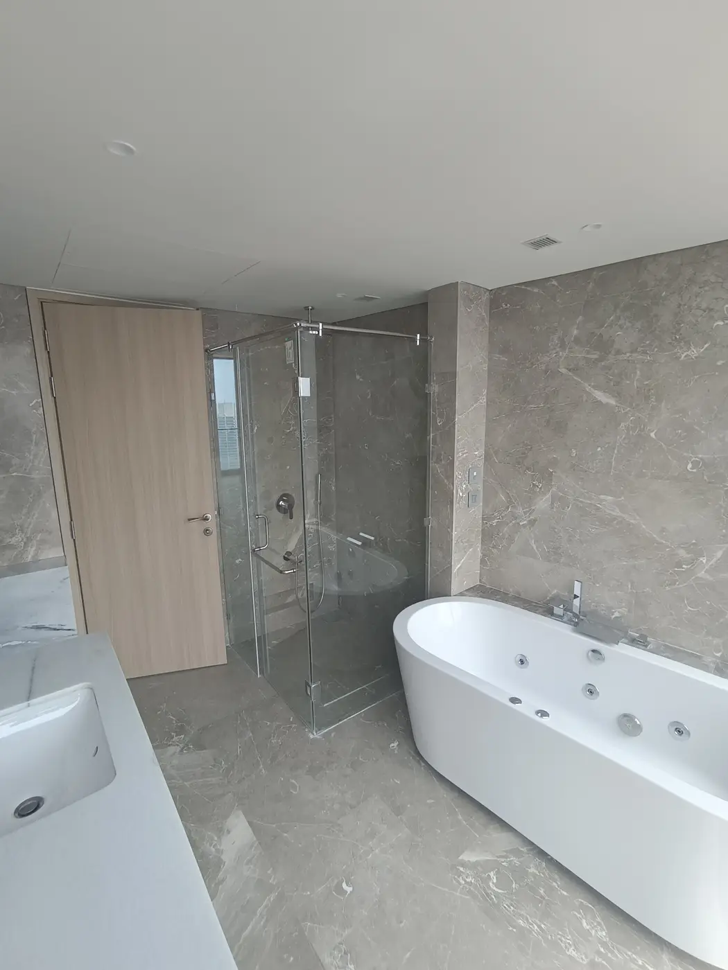 Rustomjee Crown: A bathroom with a tub and a glass shower