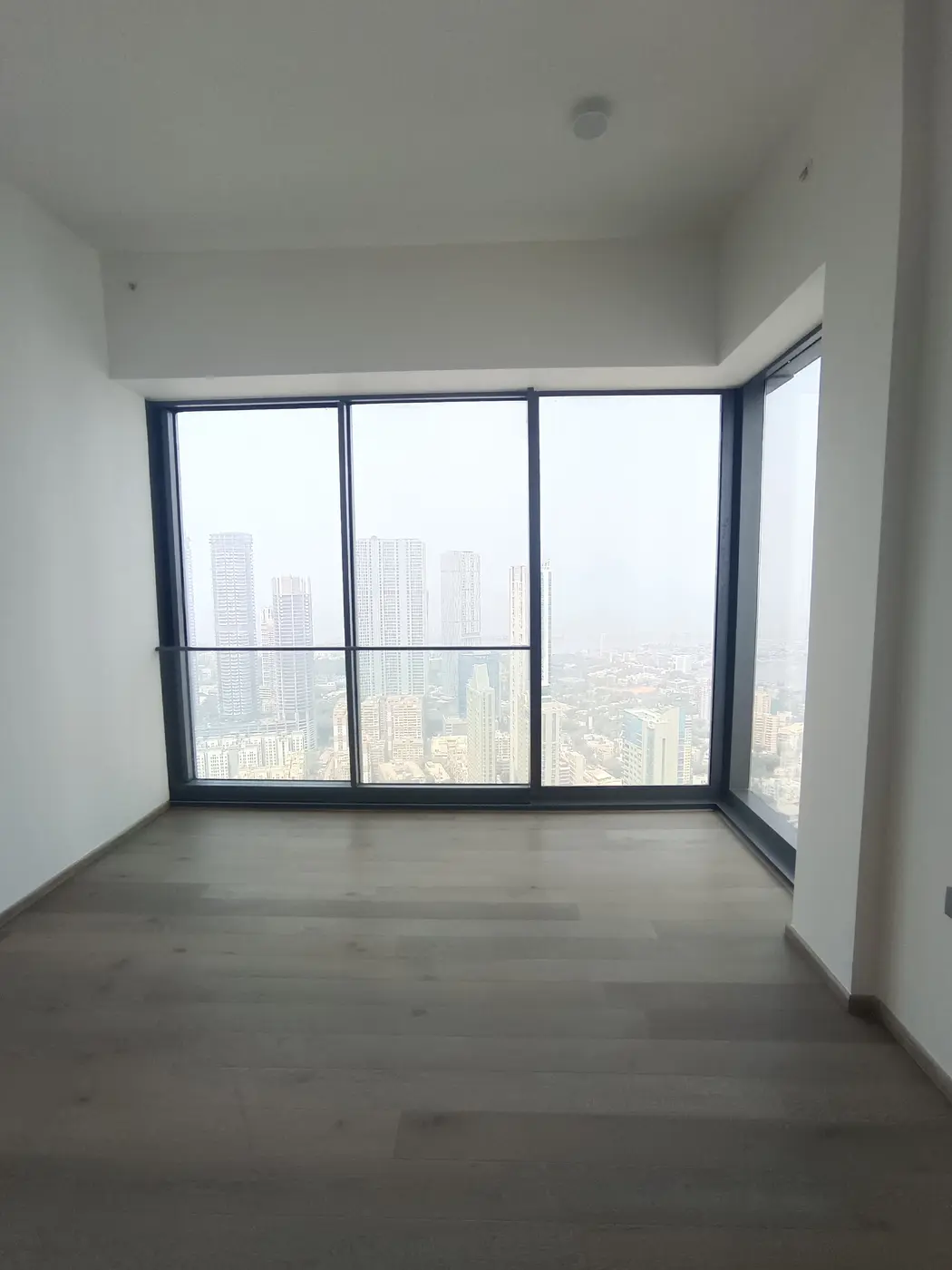 Rustomjee Crown: A builder-finished room with floor-to-ceiling windows